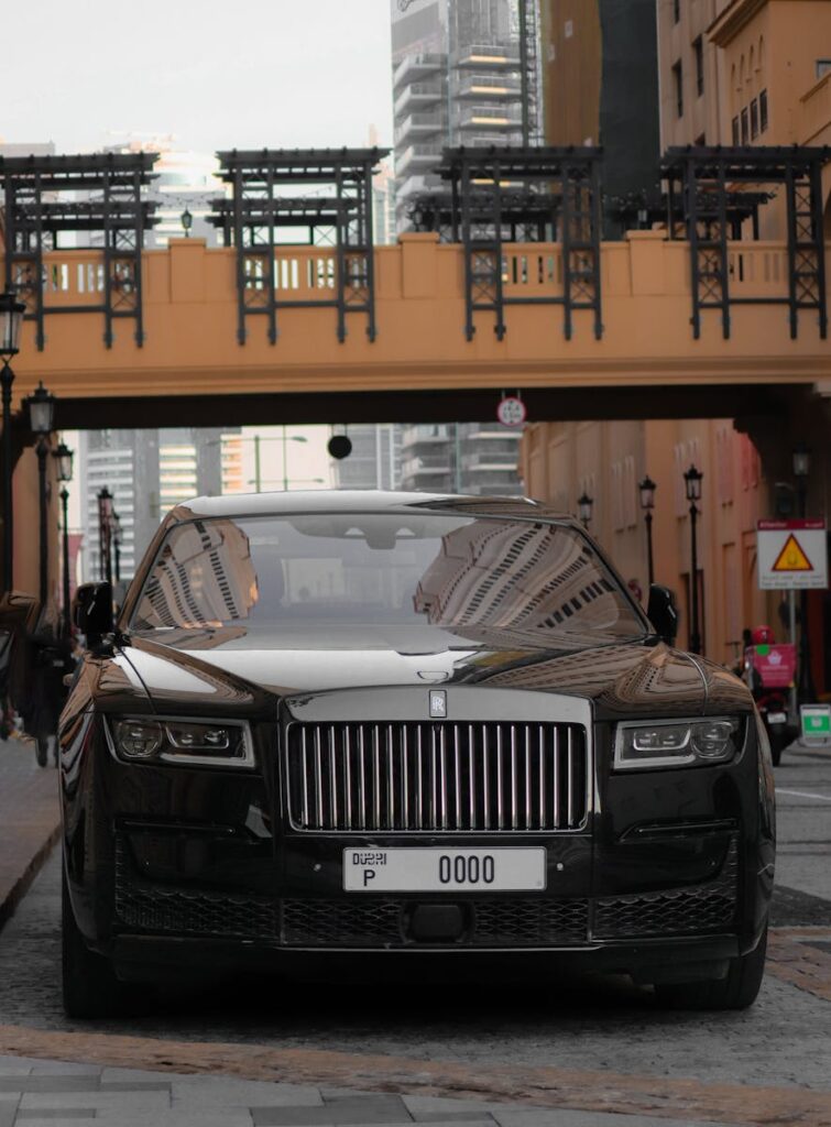 Front view of a Rolls-Royce parked in a modern cityscape, showcasing luxury and elegance.
