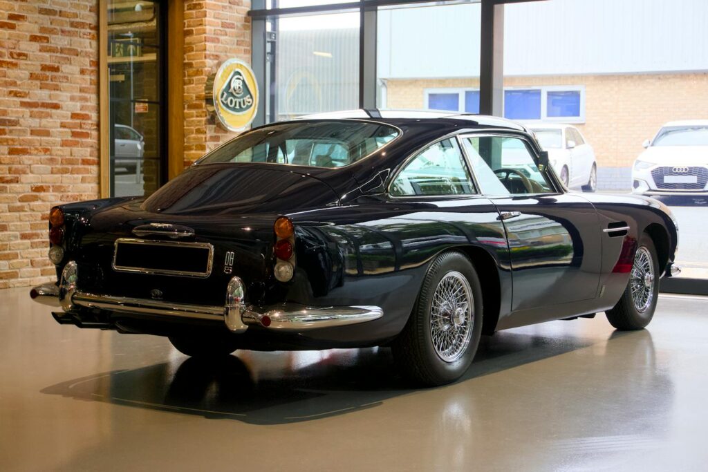 A classic Aston Martin on display indoors, showcasing timeless elegance.