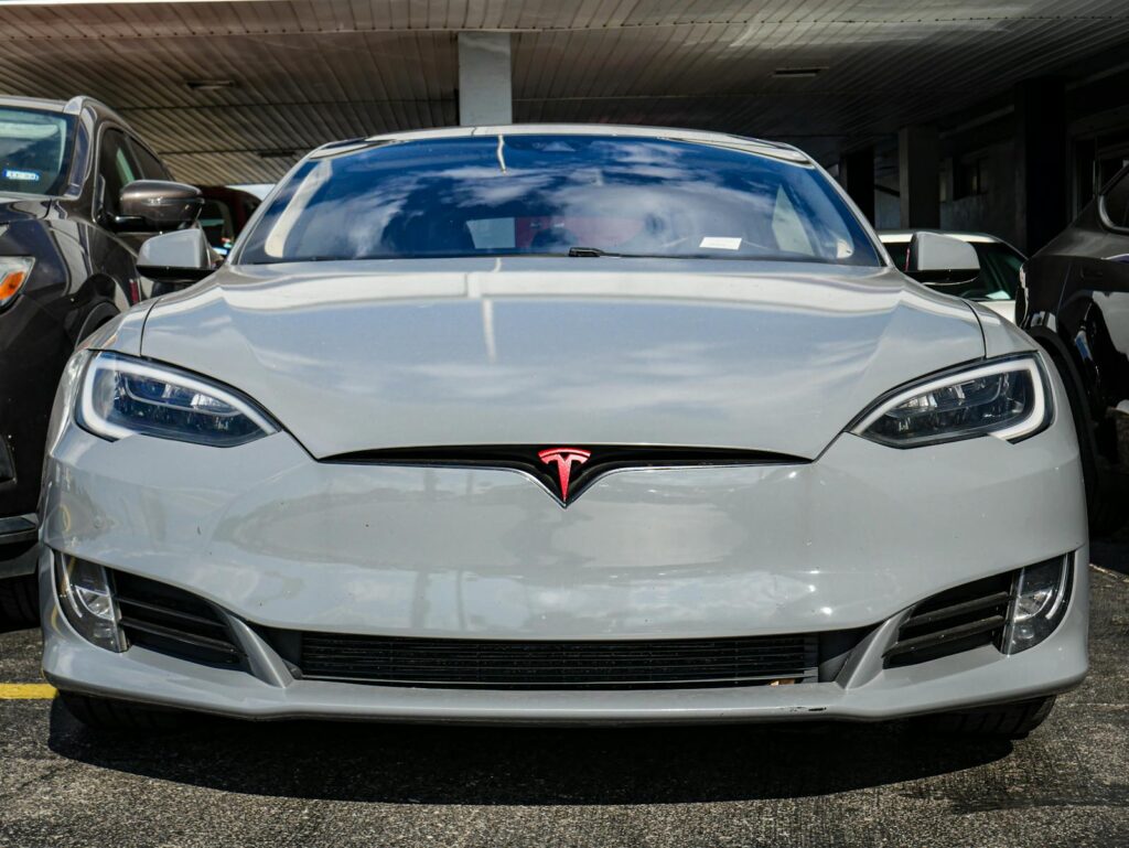 Front view of a Tesla Model S parked in an urban area, highlighting sleek design and modern aesthetics.