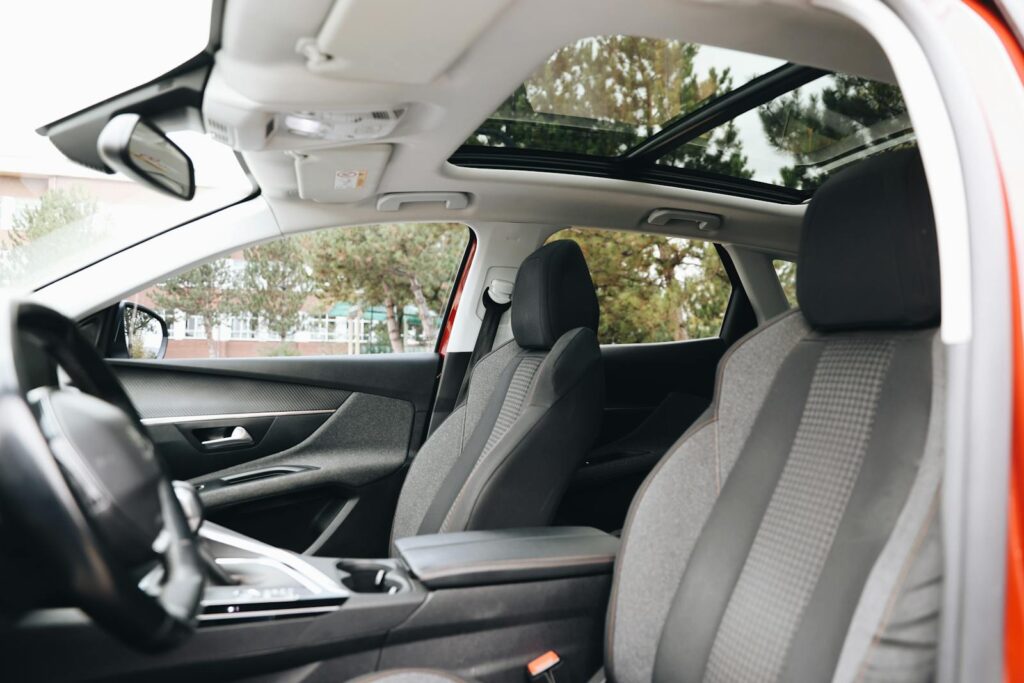 Spacious modern car interior featuring a panoramic sunroof and front seats.