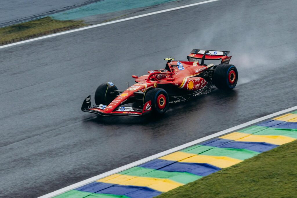 Ferrari Formula 1 car speeding through a wet track at Interlagos, capturing dynamic racing action.