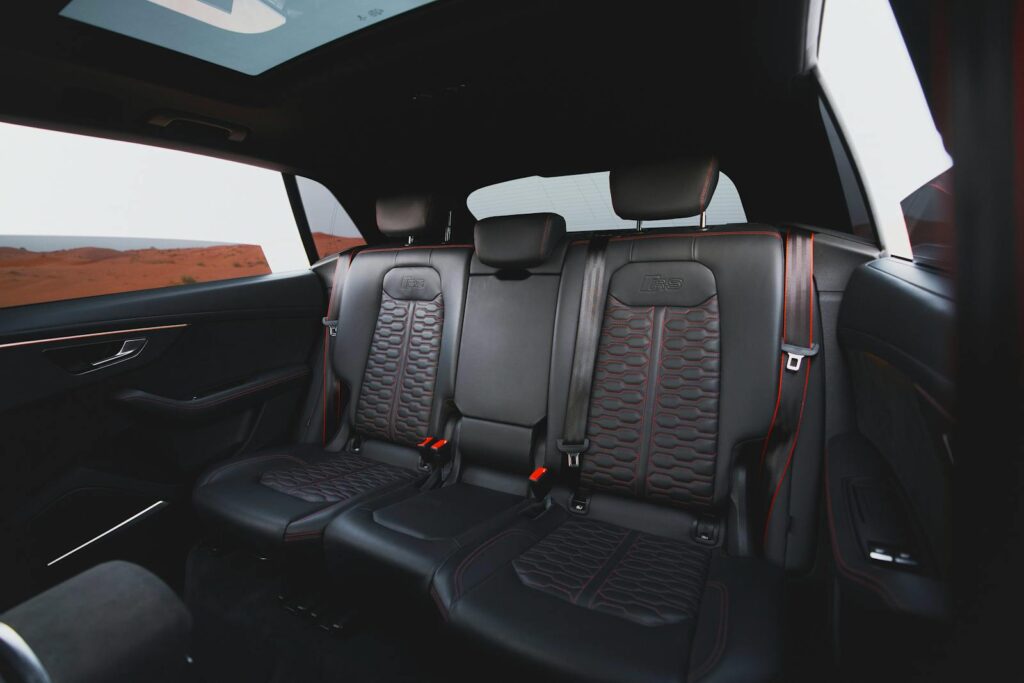 Luxurious car interior showcasing sleek custom leather seats and panoramic view.