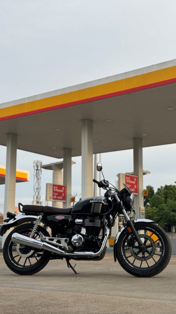 A classic black motorcycle parked at an Indian fuel station in Chennai, India.