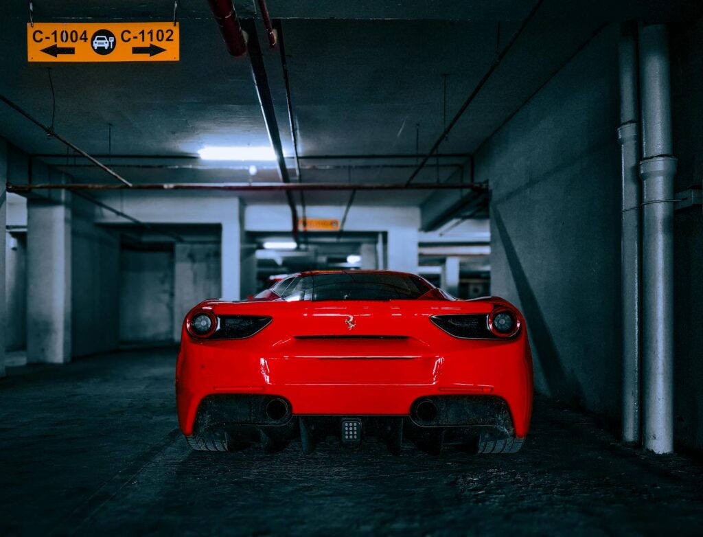 A striking red Ferrari 488 GTB parked in an underground garage in Mumbai.
