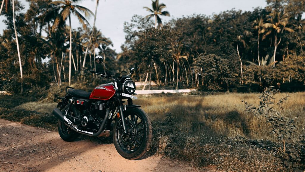 Vintage Honda motorcycle parked on a rural road in lush Thiruvananthapuram, India landscape.