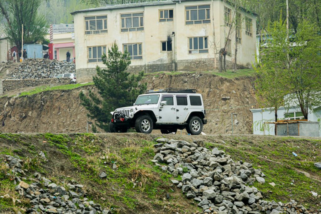 A rugged vehicle parked on rocky terrain in Badakhshan, Afghanistan, showcasing adventure travel.