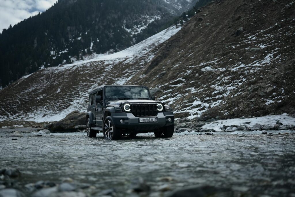 A rugged SUV on a wintery mountain trail in Sonamarg, showcasing adventure.