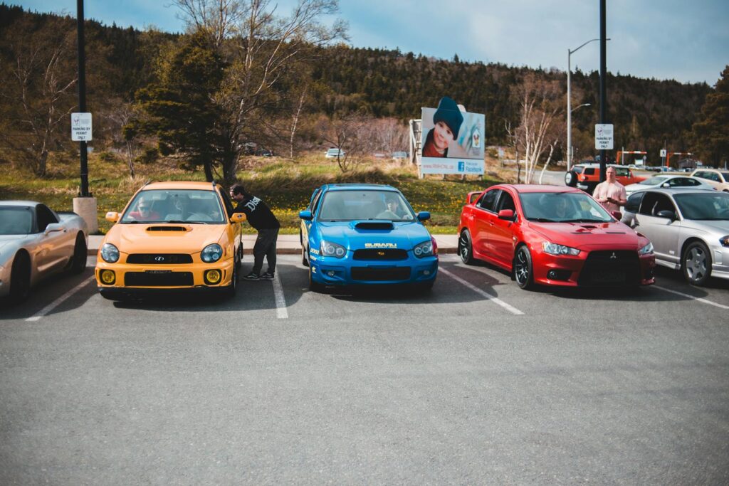 Colorful cars showcased outdoors in an urban parking lot on a sunny day.