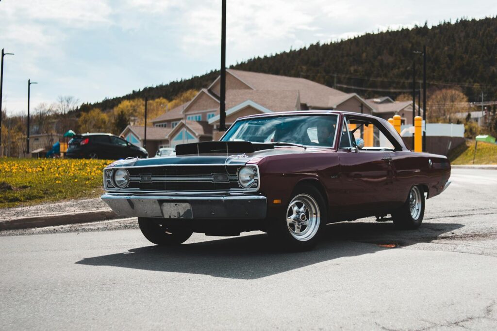 A classic vintage car parked on a street under the sun, showcasing timeless automotive design.