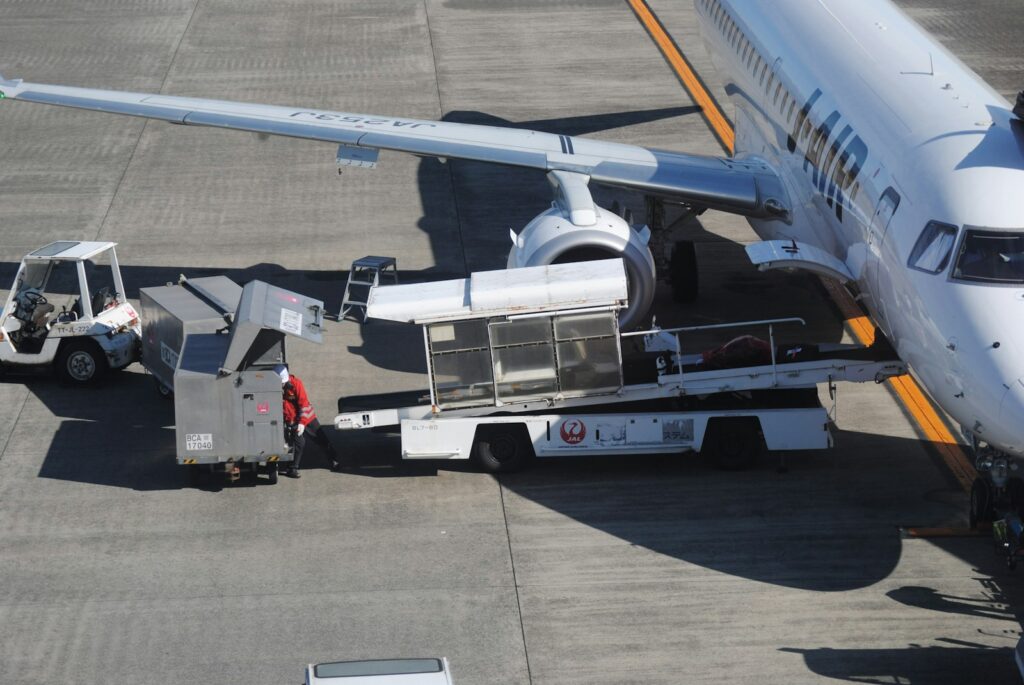 Ground crew loading luggage onto an airplane.