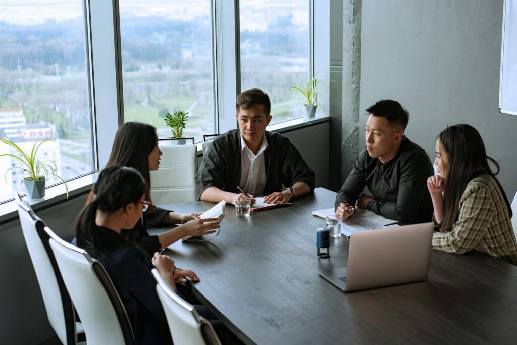 Group of Asian professionals having a meeting in a modern office setting.