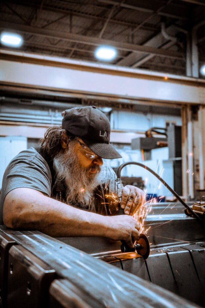 A man is grinding metal in a factory.