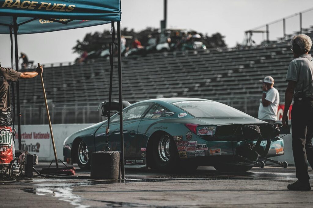 Captured moment at a drag race in Topeka, featuring a high-speed race car and pit crew.