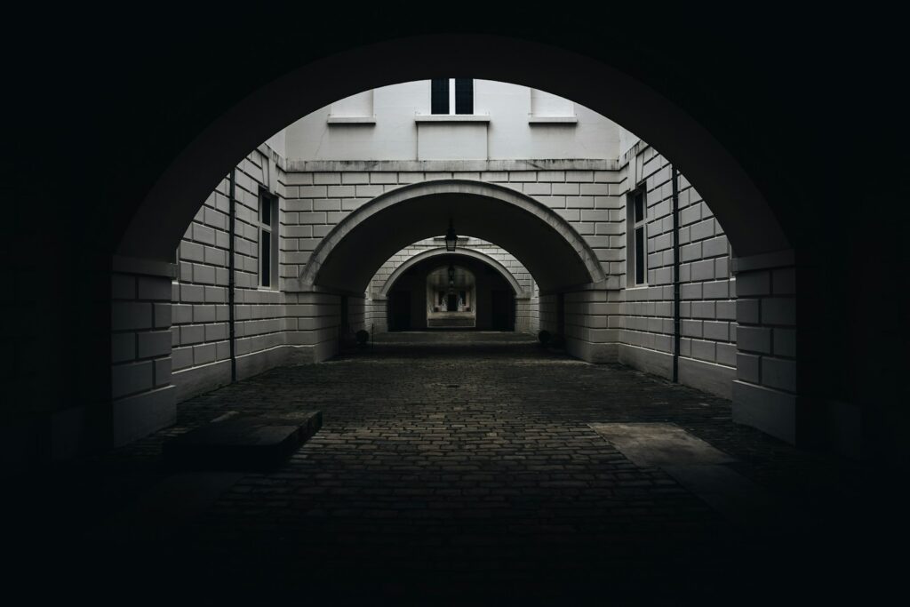 a dark tunnel with a clock on the wall