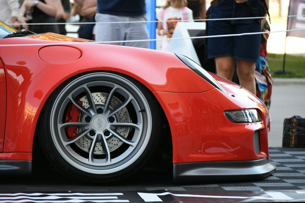 Red sports car with custom wheels at an event