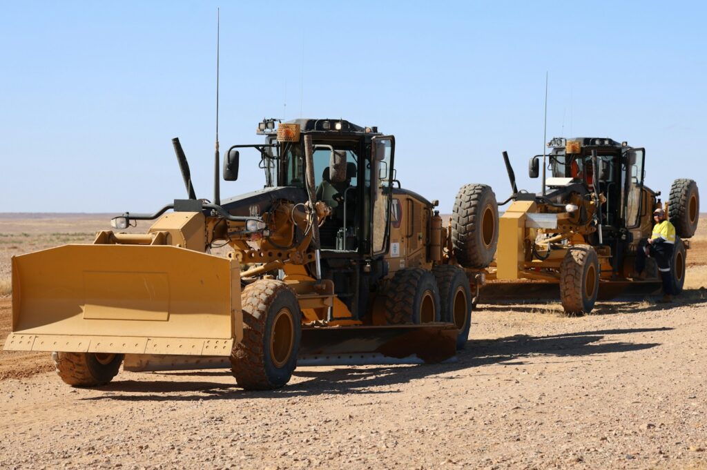 Two heavy-duty construction vehicles are on the ground.