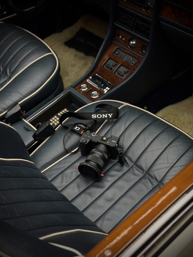 A sony camera rests on vintage car seats.