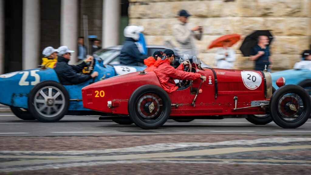 Vintage race cars competing on a street circuit.