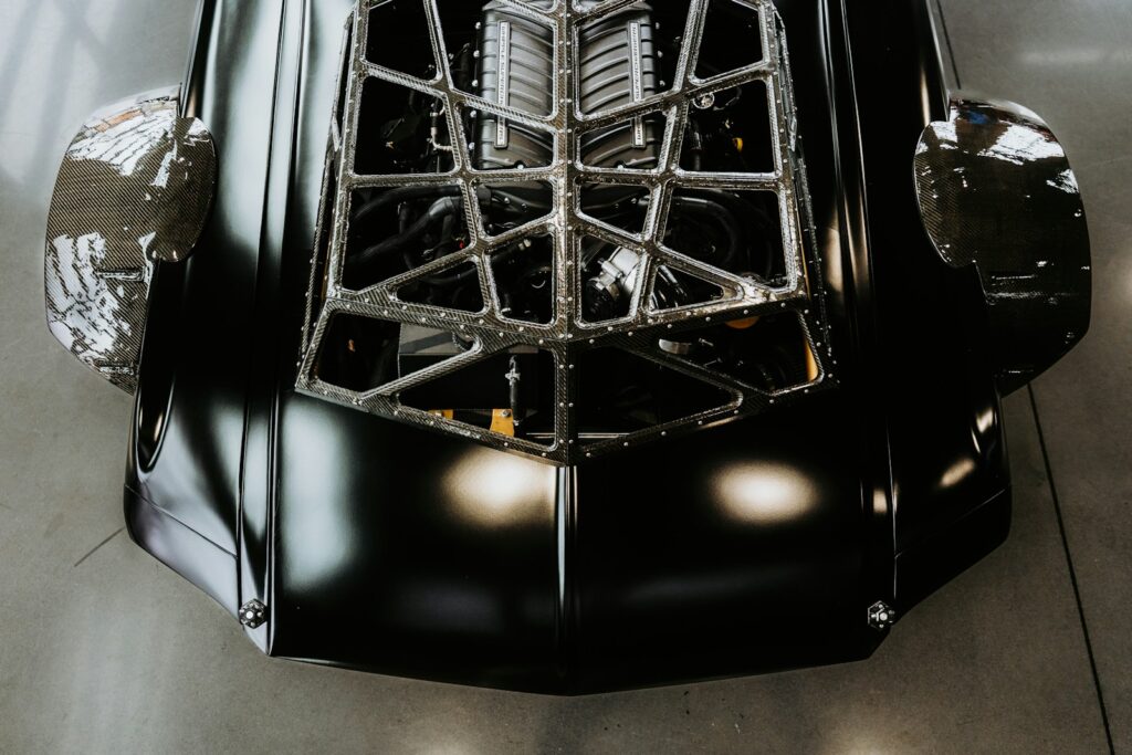 A black car's engine compartment is exposed.