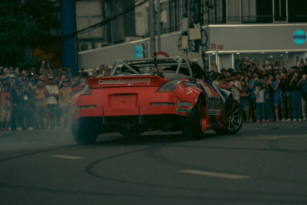 A car is drifting for a cheering crowd.