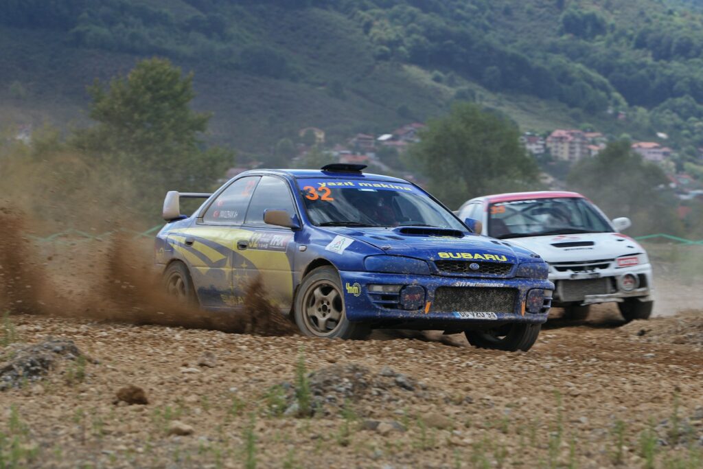 Two rally cars racing on a dirt track