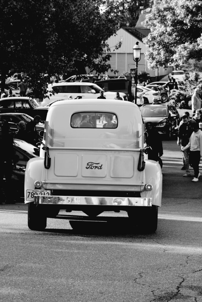 A black and white photo of a car driving down a street
