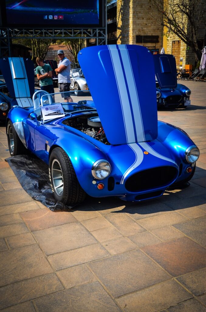 A blue and white car parked on top of a sidewalk