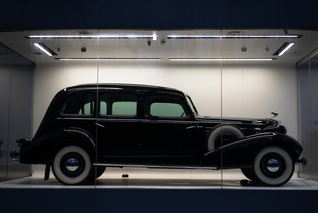 a black car is on display in a glass case