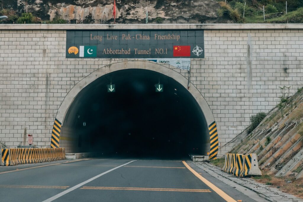 A road going into a tunnel with a mountain in the background