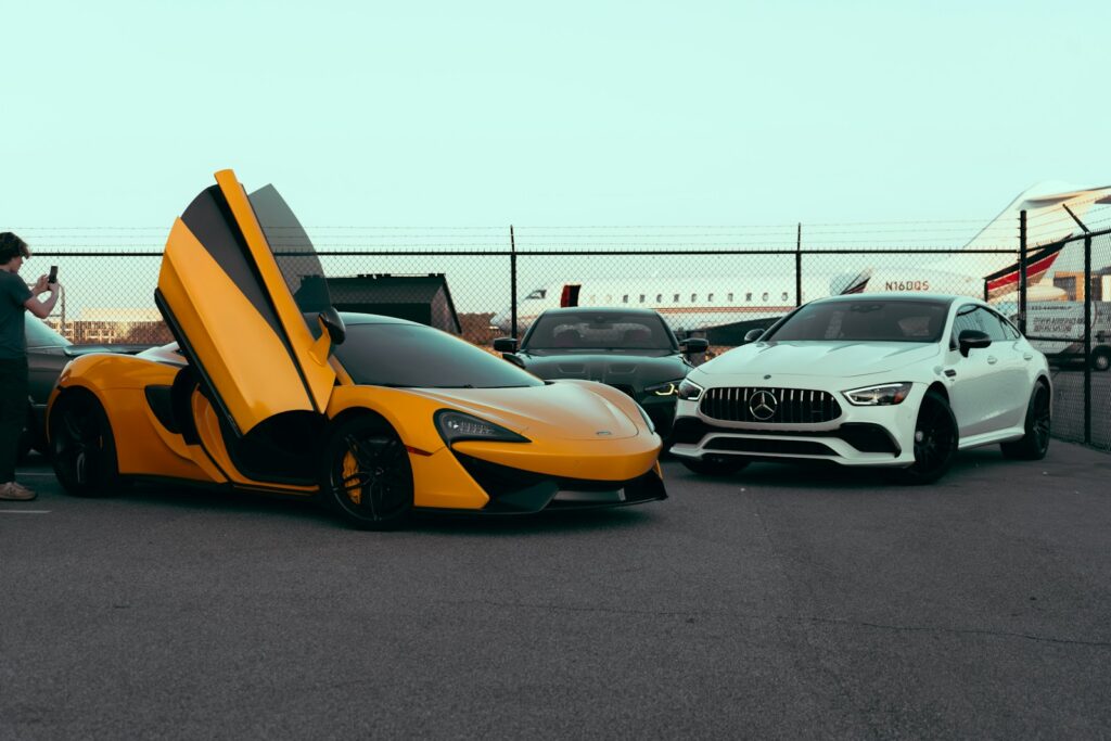 A man standing next to a yellow sports car