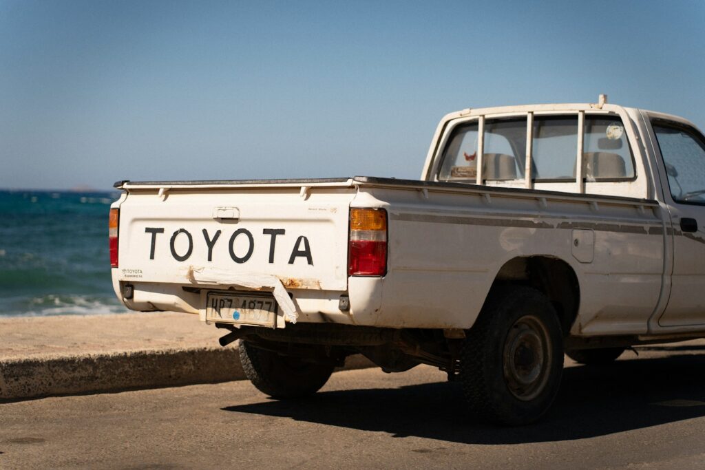 White toyota pickup truck parked by the ocean
