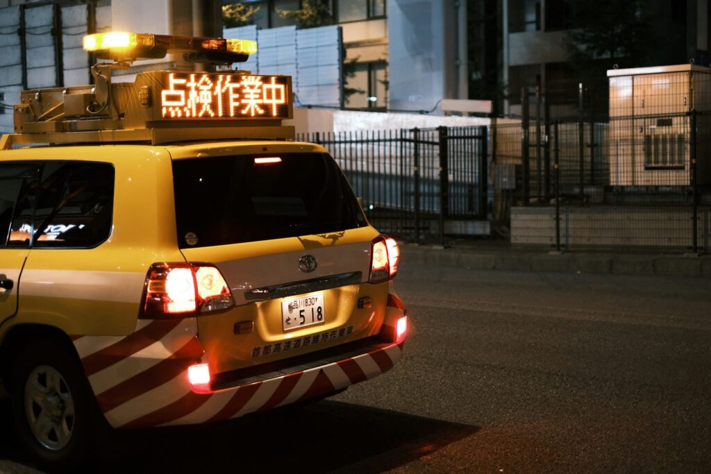 Yellow vehicle with flashing lights and warning signs.