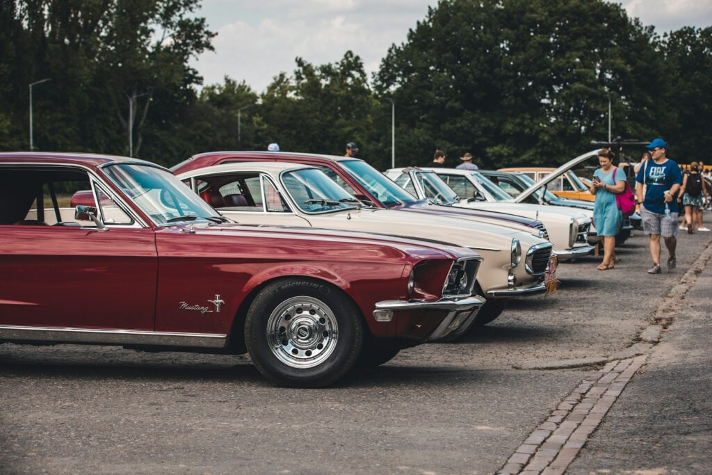 a row of old cars parked in a parking lot