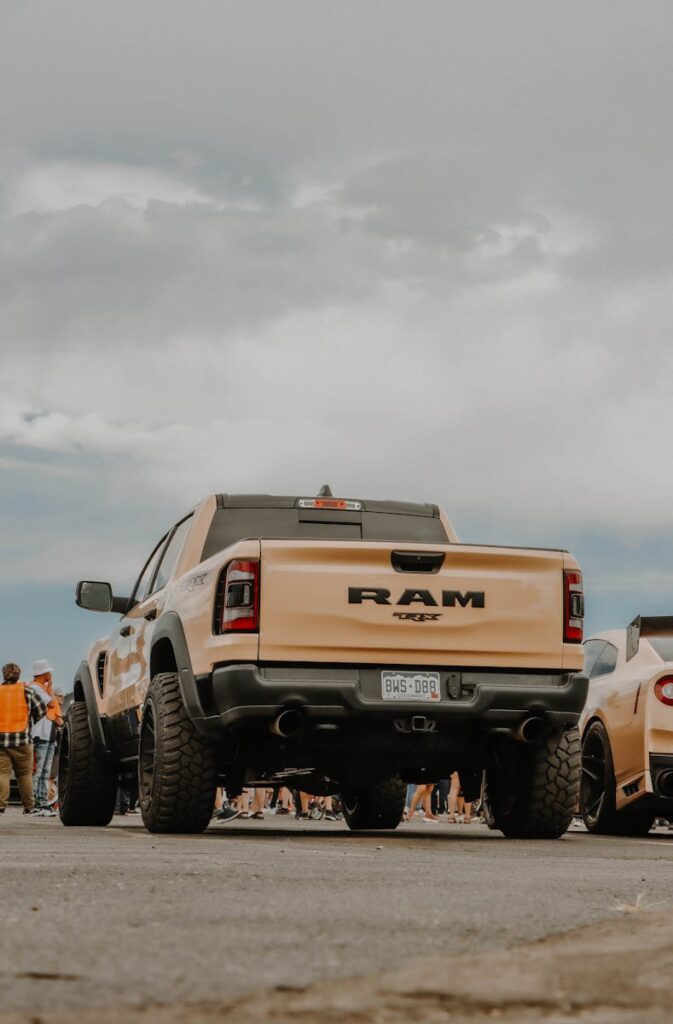 A robust RAM truck displayed at an outdoor car show under a clear blue sky, capturing automotive strength.