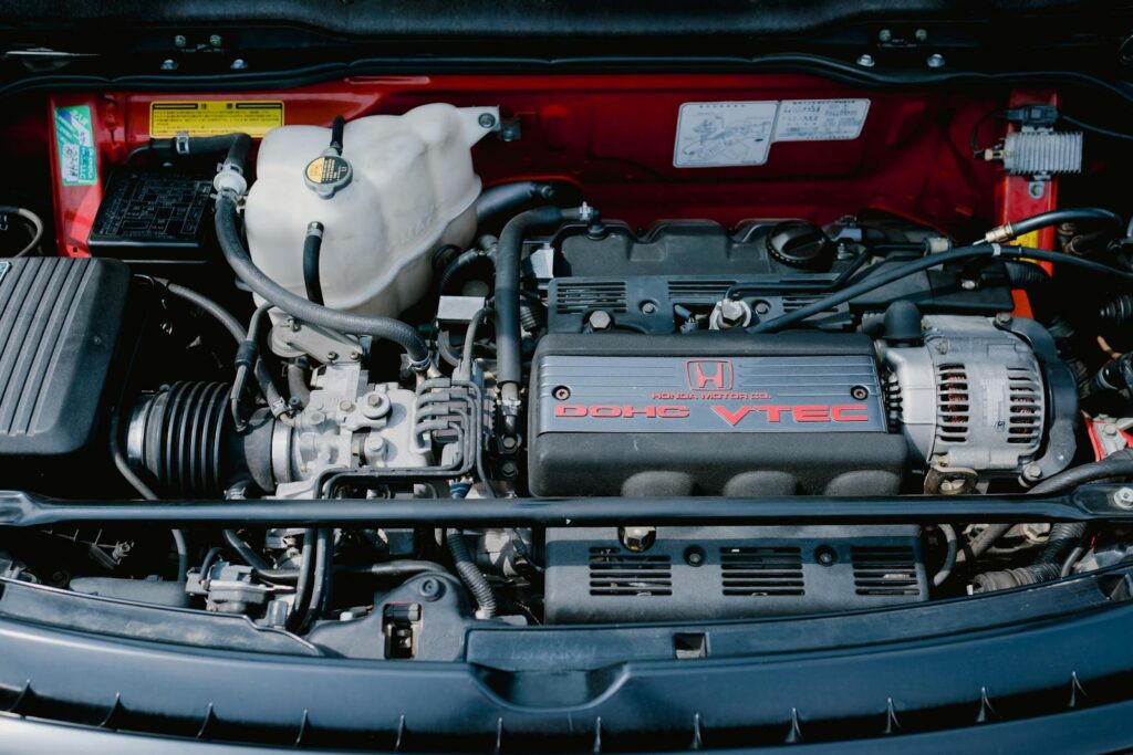 Close-up of a Honda DOHC VTEC engine inside a vehicle, showcasing components.