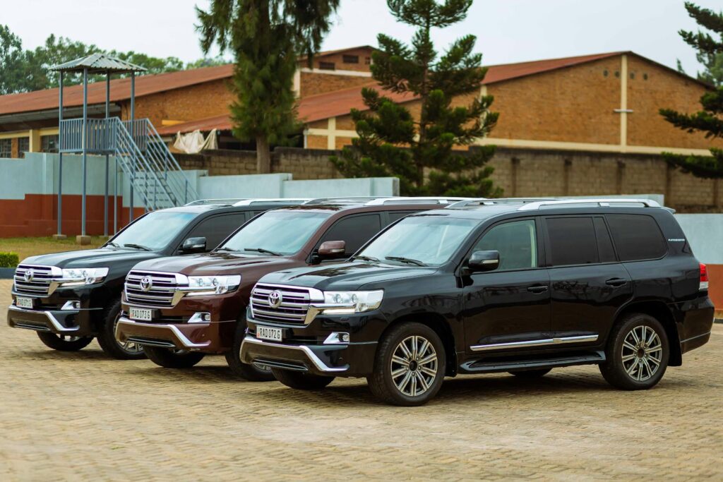 Three black Toyota Land Cruisers parked in an outdoor setting, showcasing their sleek design.