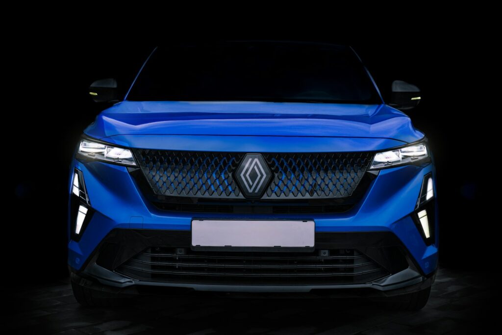 A blue car is shown in the dark