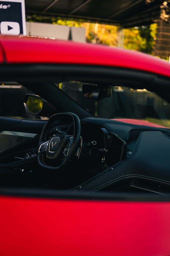 Interior of a red sports car with steering wheel.