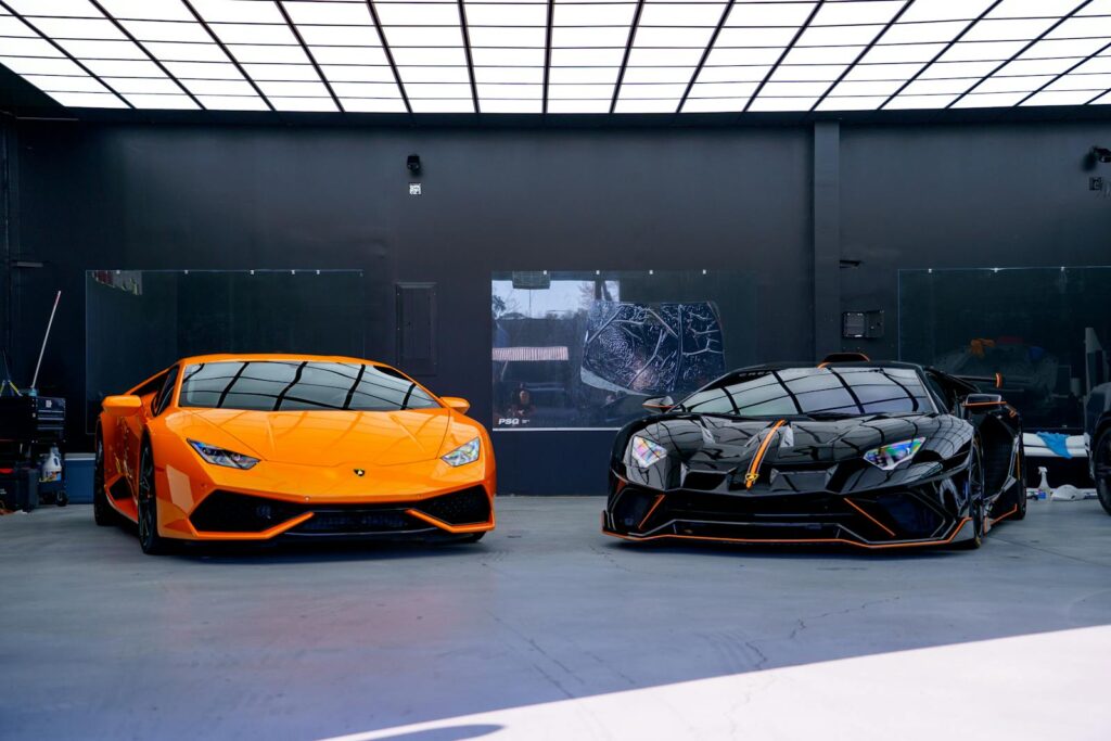 Dynamic display of orange and black luxury sports cars in a modern showroom, ideal for automotive enthusiasts.