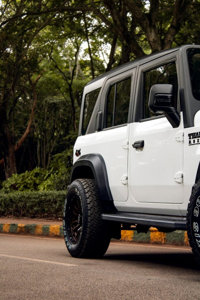 White SUV parked on a road surrounded by lush greenery in Bengaluru, India.
