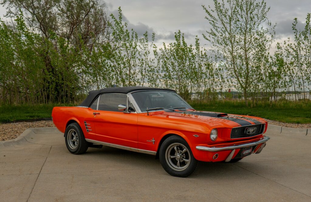 An orange mustang sitting in a parking lot