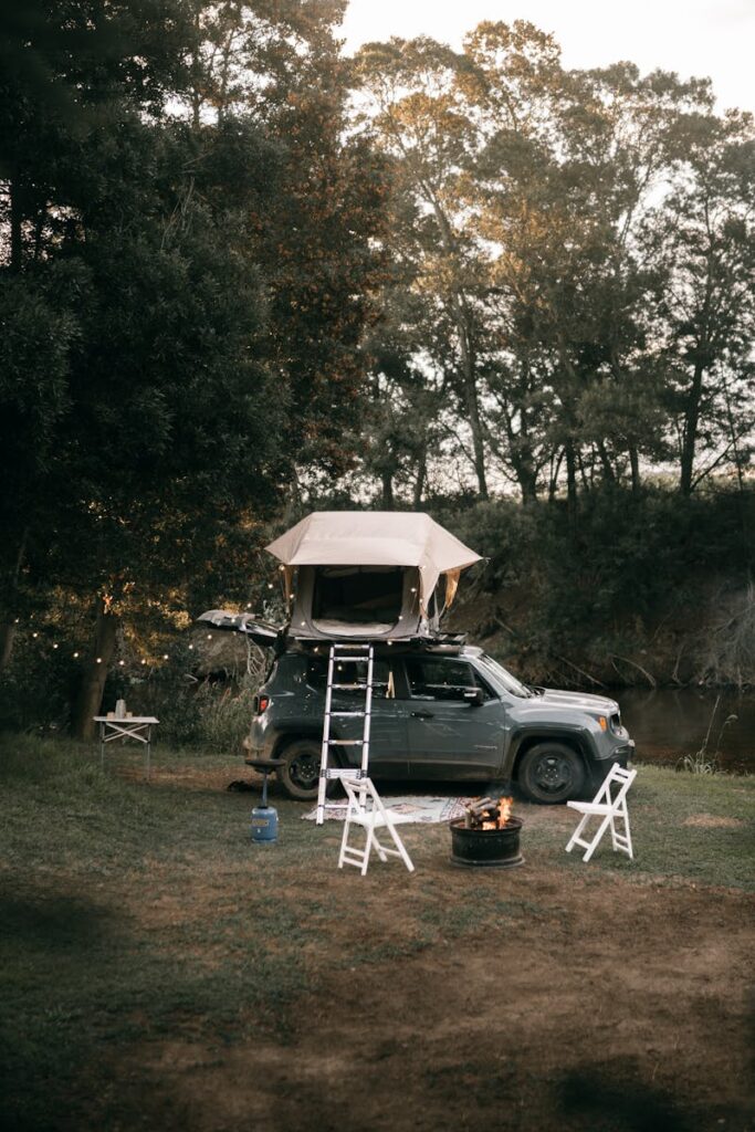 Explore the outdoors with a cozy car campsite beside a river.