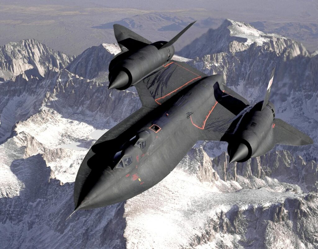 Lockheed SR-71 Blackbird flying over a snowy mountain range, showcasing advanced military aviation.