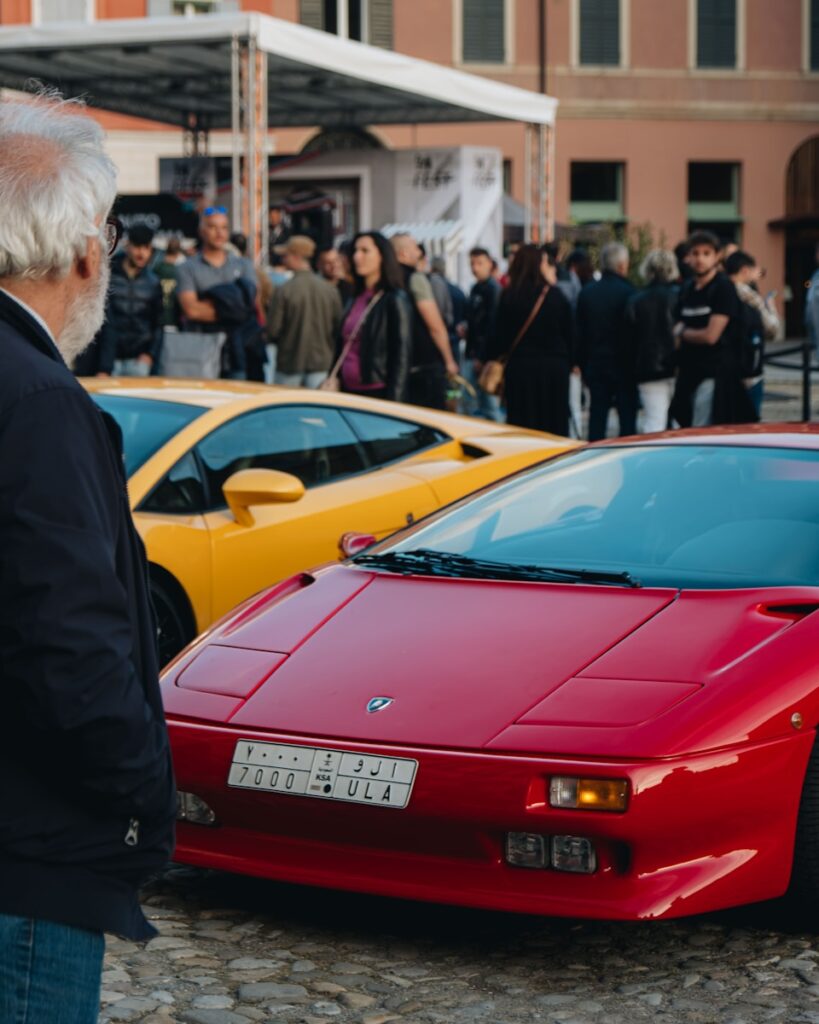 a man standing next to a red sports car