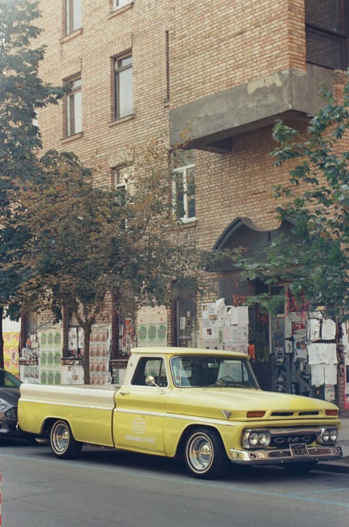 A yellow truck parked on the side of a road