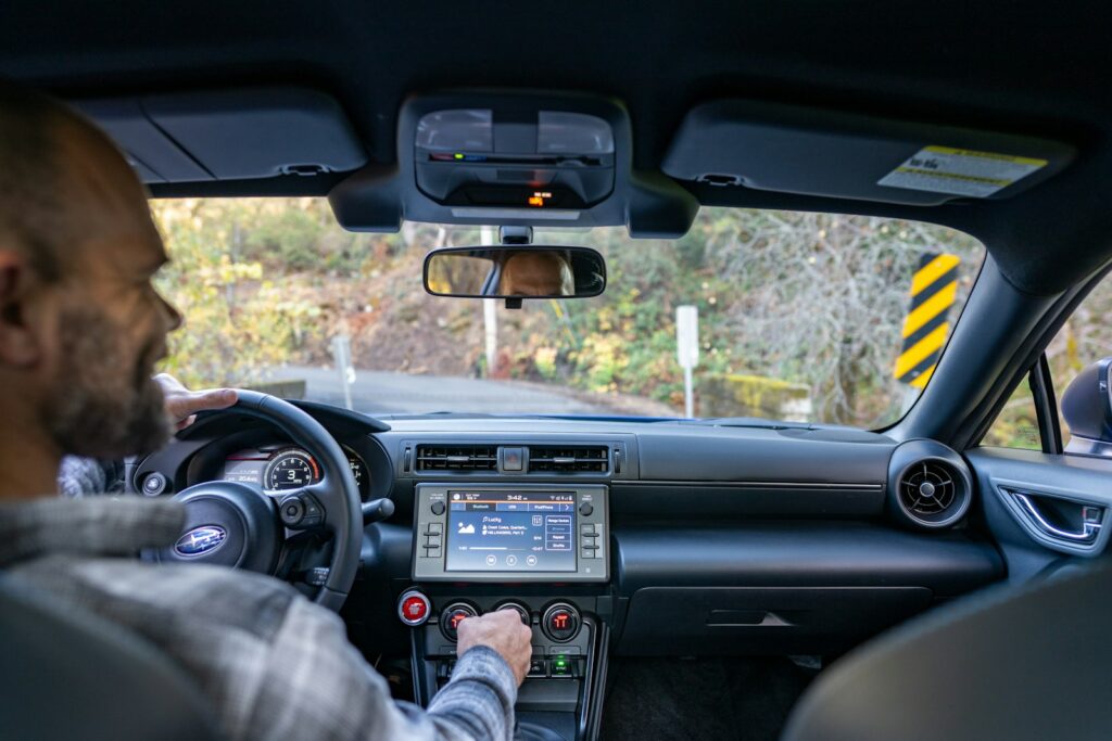 A man driving a car with a gps device in his hand