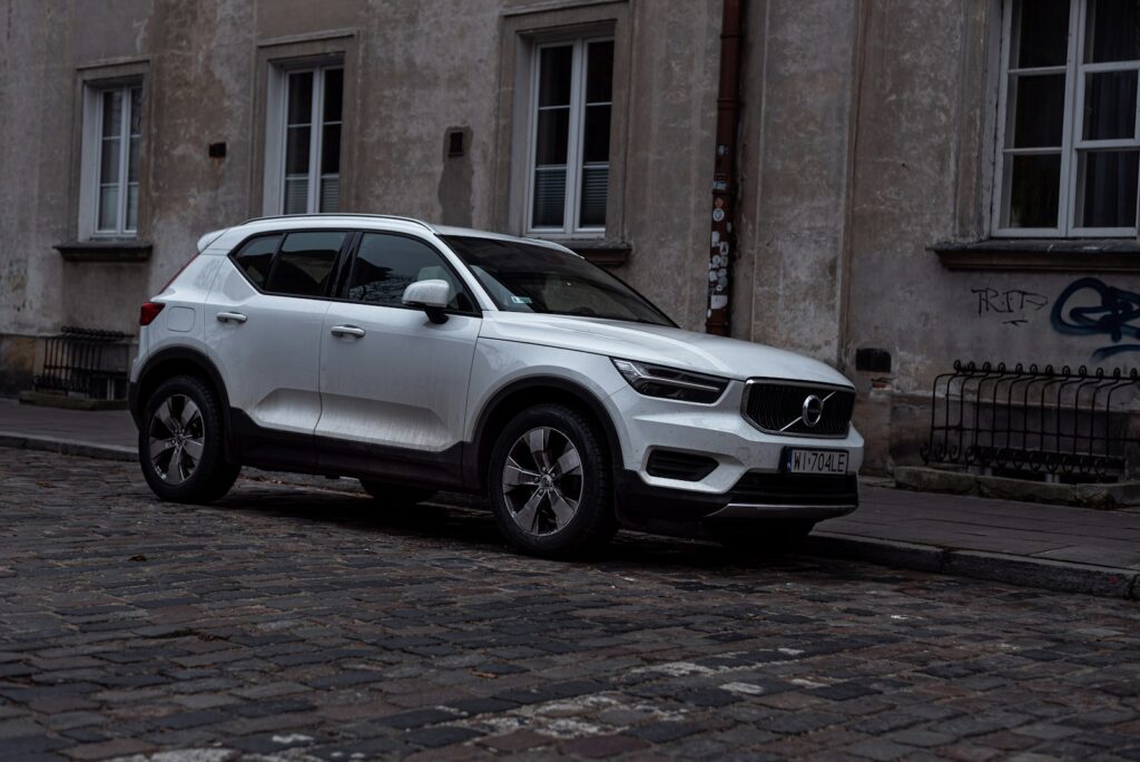 a white volvo car parked on a cobblestone street