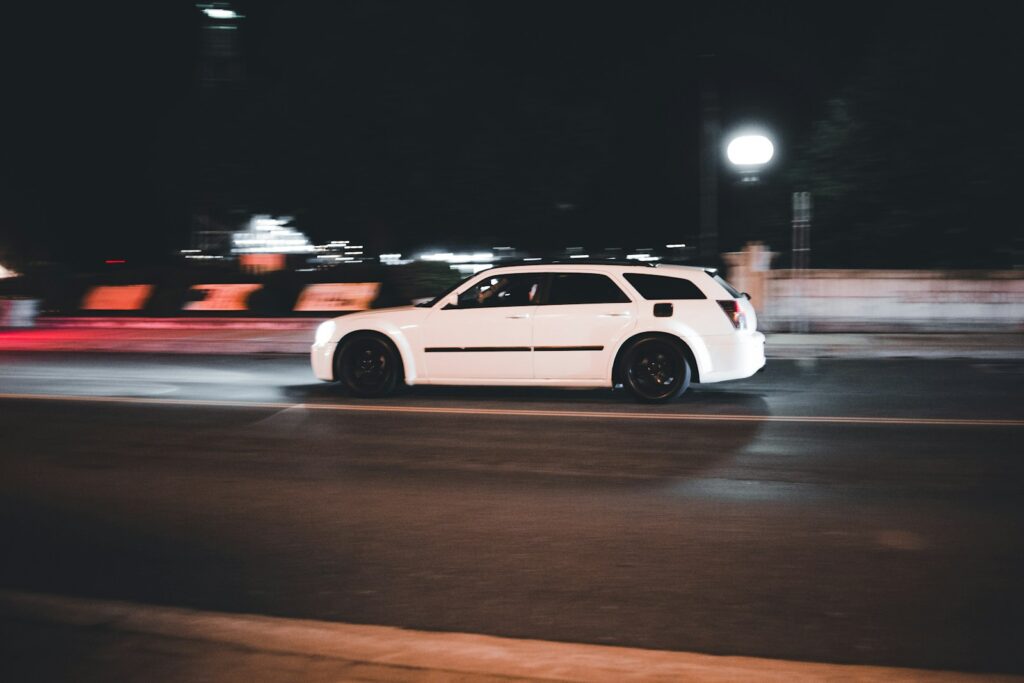 a white car on a road at night