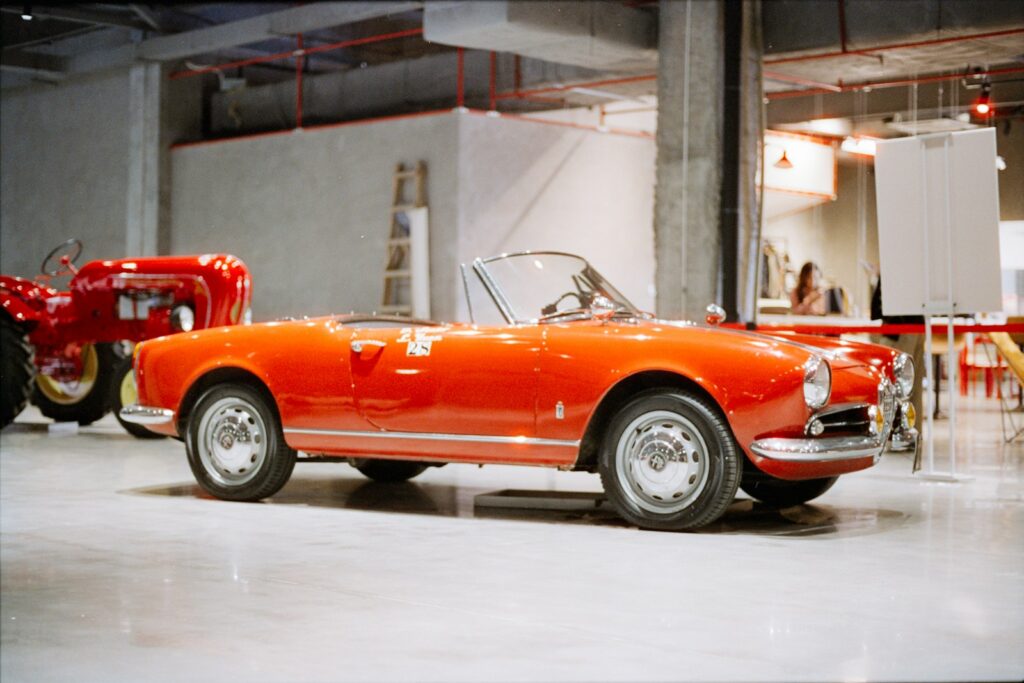 A vintage orange convertible car on display