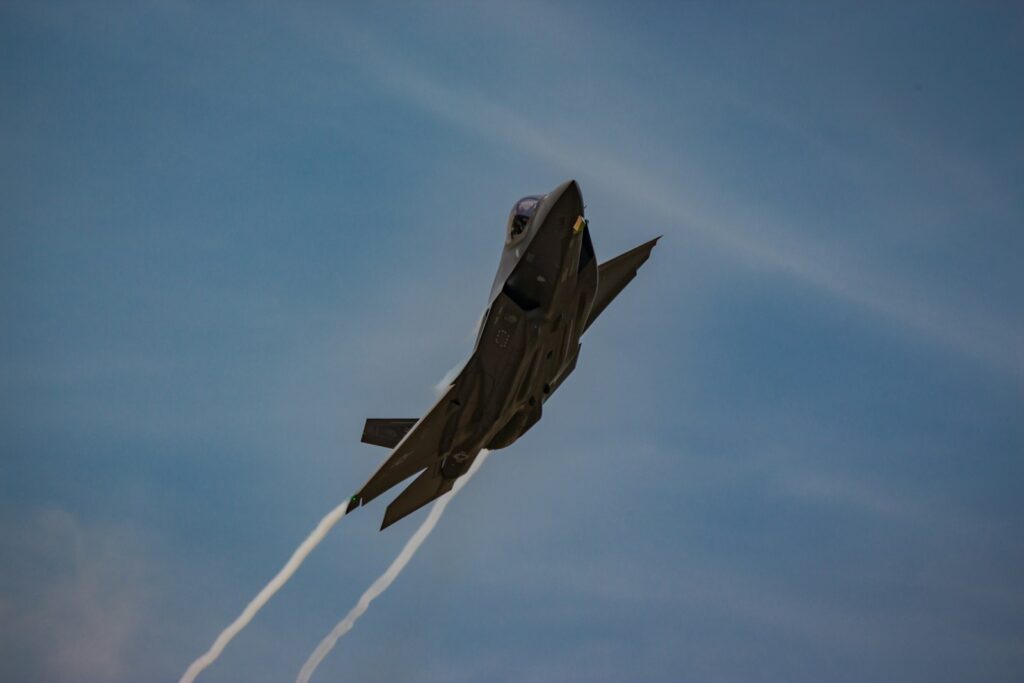 A fighter jet flying through a blue sky